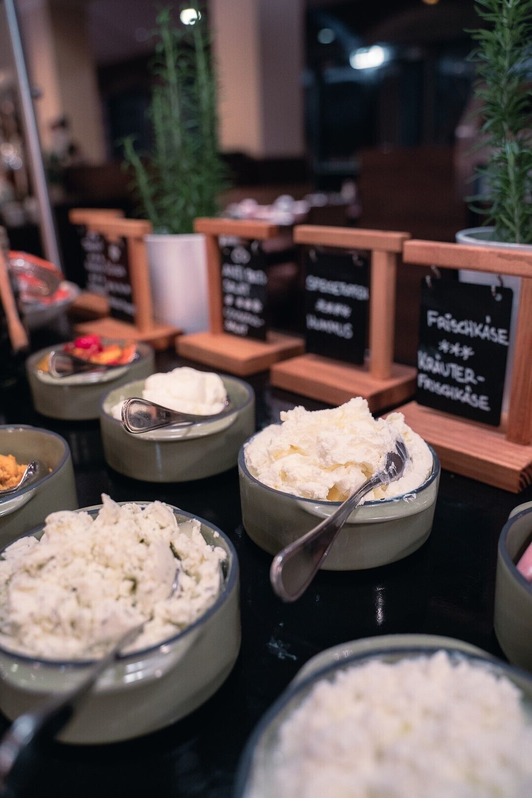 A buffet with various food items, including a bowl of cottage cheese, a bowl of rice, and a bowl of salad. There are also signs indicating different food sections.
