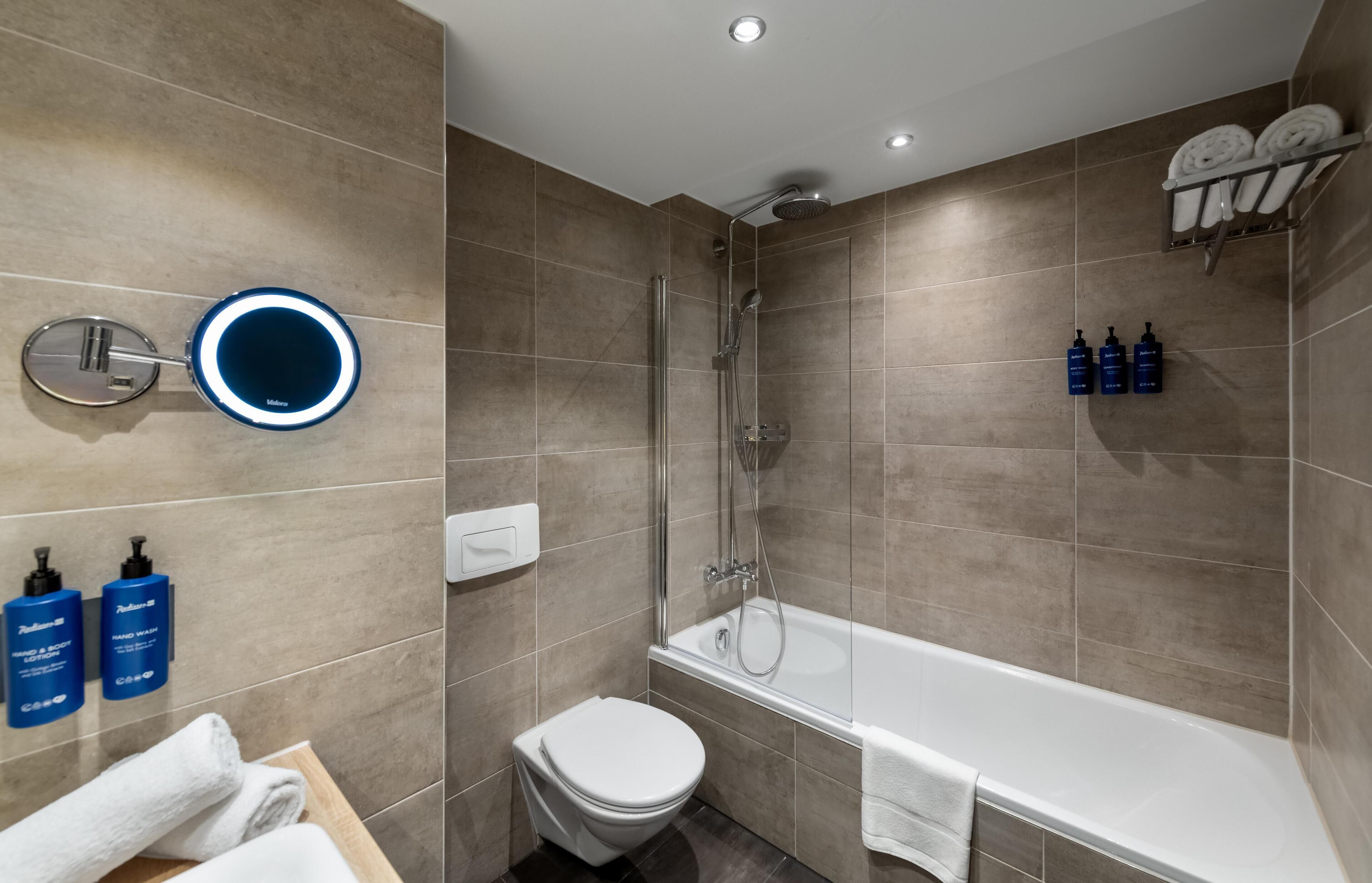 Ein modernes Badezimmer mit Badewanne, Toilette und Handwaschbecken.