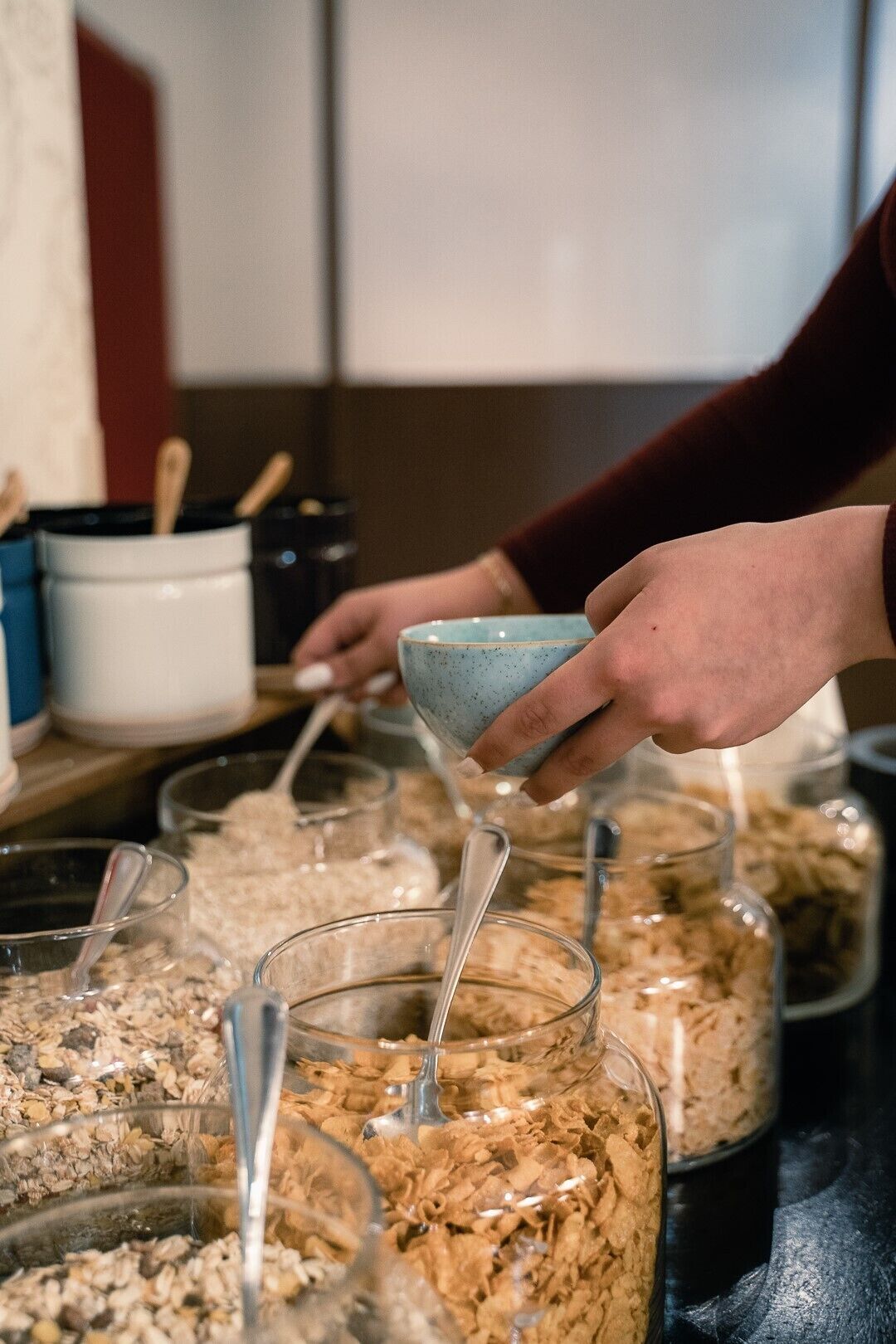 A person pouring cereal into a bowl from a large container.