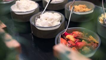 A buffet with various dishes including a bowl of soup and several bowls of what appears to be rice or a similar grain dish.