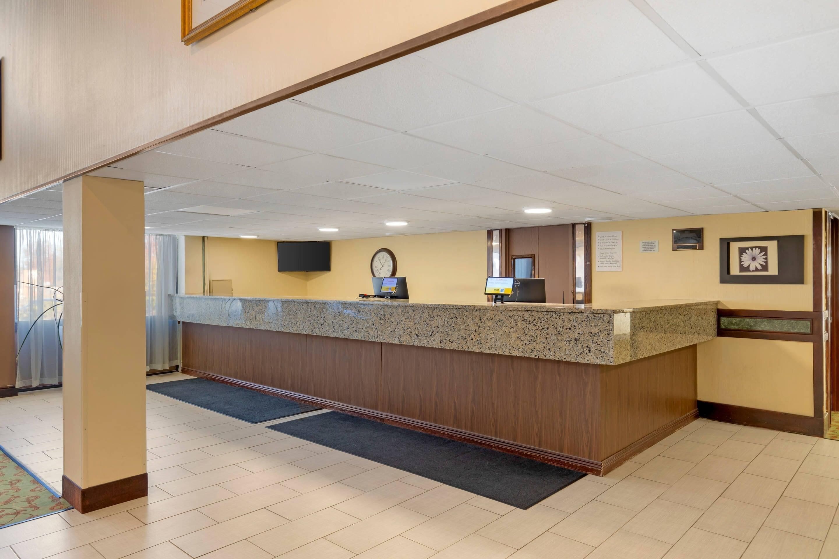 A reception area with a counter, a clock, and a framed picture on the wall.