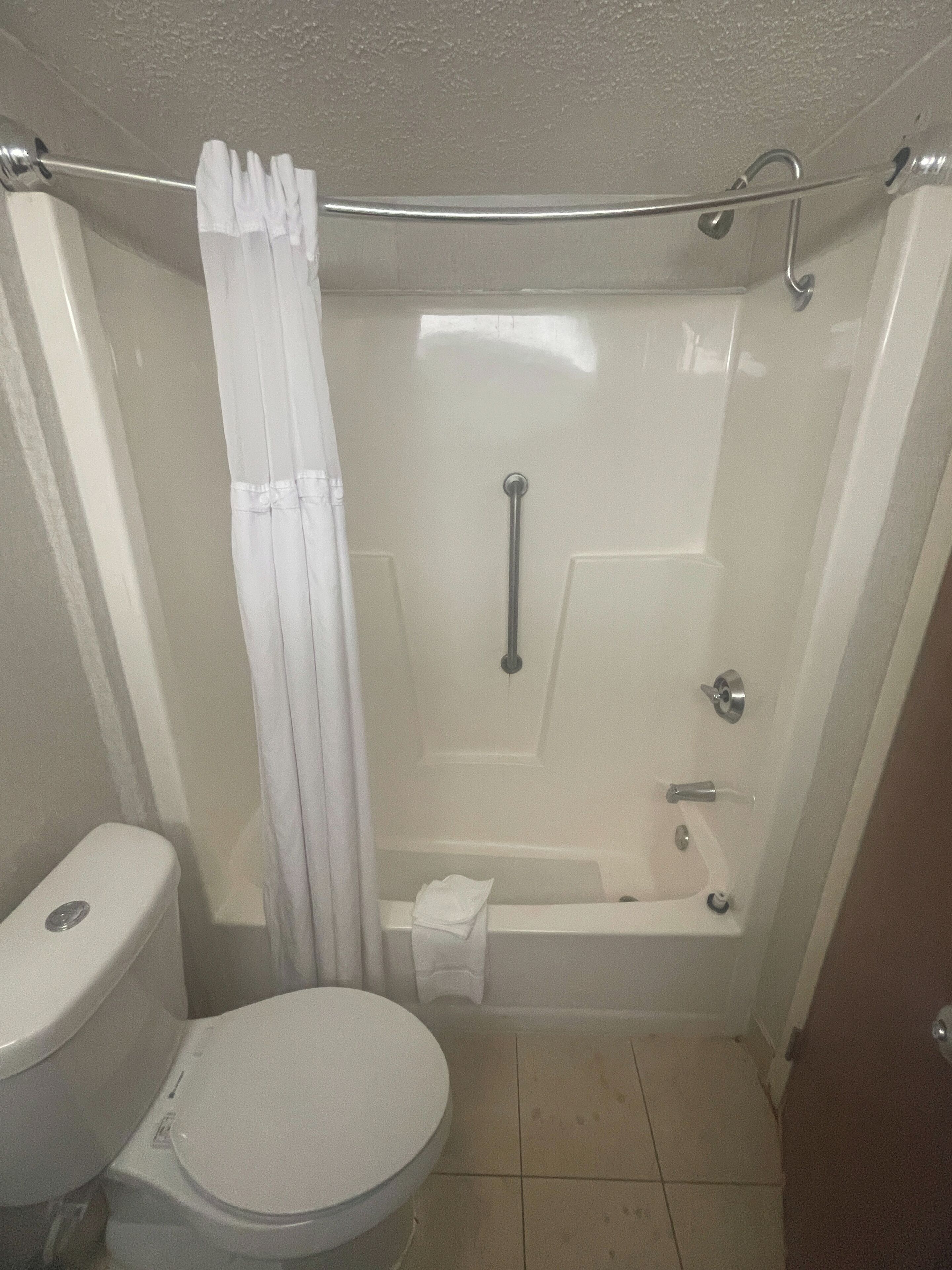 A bathroom with a toilet, a shower with a glass door, and a bathtub.