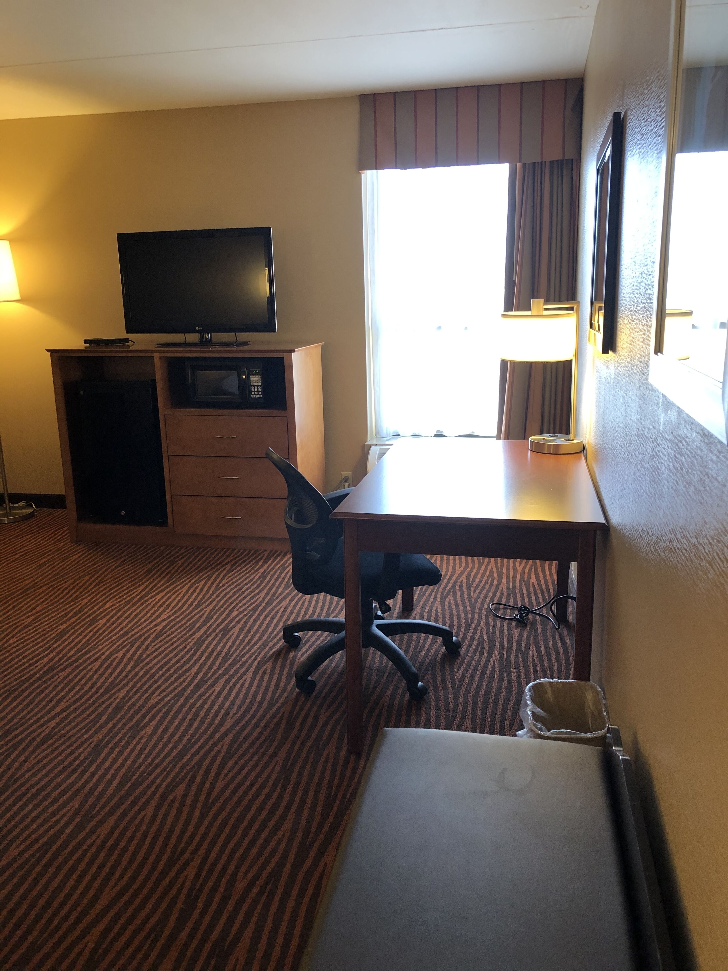 Une chambre d’hôtel équipée d’un bureau, d’une chaise, d’une télévision et d’un lit.