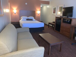 A hotel room with a bed, a sofa, a desk, a television, and a microwave. - Best Western Executive Hotel Of New Haven - West Haven (West Haven)