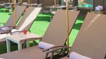 Una piscina al aire libre de temporada, sombrillas