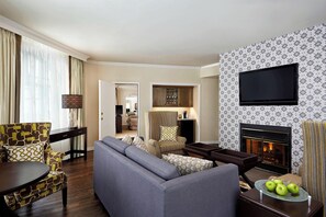 A living room with a sofa, armchairs, a TV, and a fireplace. - Algonquin Resort St Andrews by-the-Sea Autograph Collection (St. Andrews)