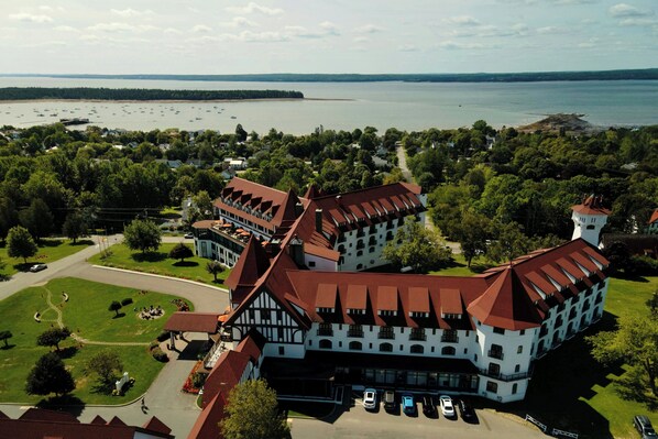 A large, historic building with a central tower, surrounded by lush greenery and a body of water. - Algonquin Resort St Andrews by-the-Sea Autograph Collection (St. Andrews)
