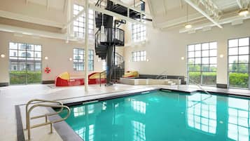 Swimmers can enjoy a rectangular pool surrounded by a tiled deck and a metal handrail for safety.