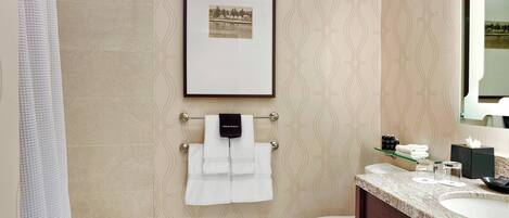 A bathroom with a bathtub, toilet, sink, and a framed picture on the wall.