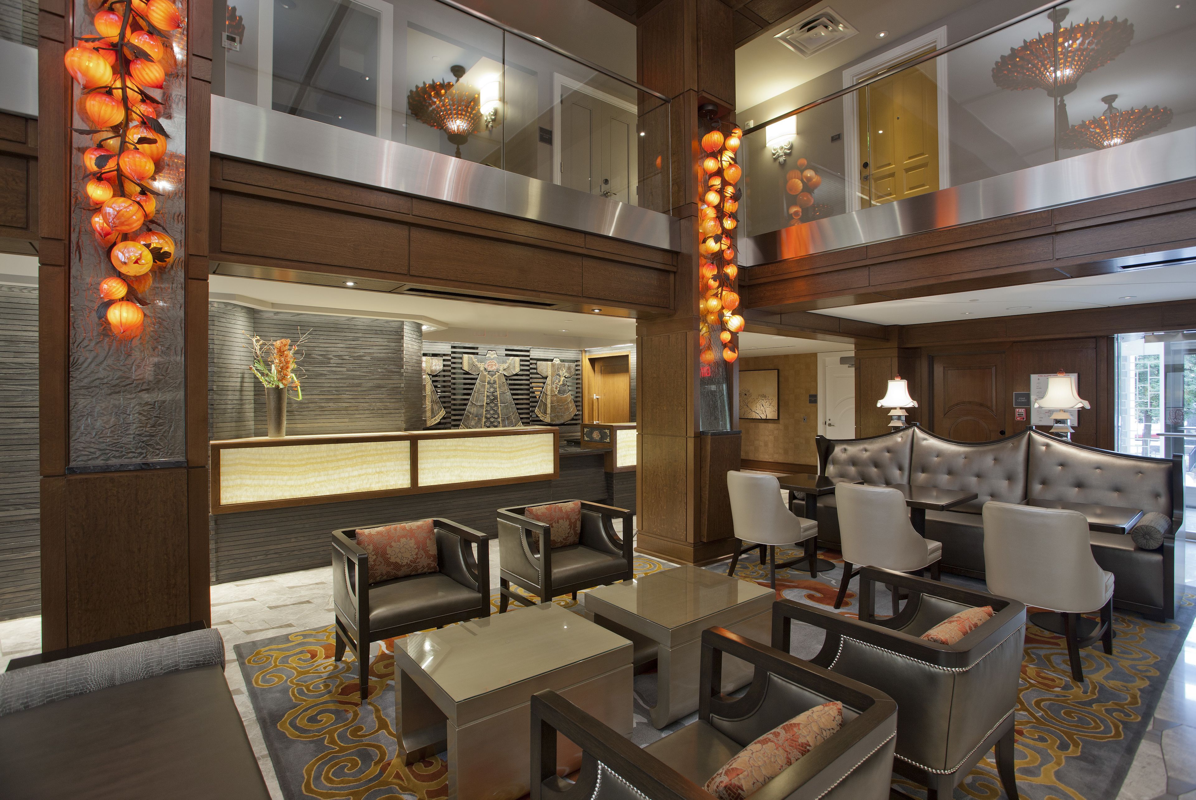 A spacious lobby with a seating area, a reception desk, and a view of the upper floor.