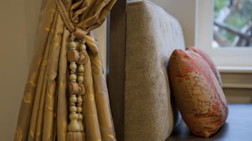 Quarto com sofá, cortina decorativa e janela.