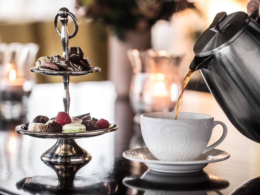 A tray of assorted desserts and a cup of coffee on a table.