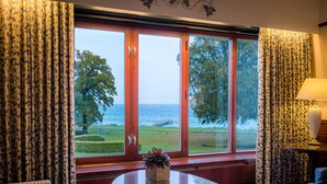Ein Zimmer mit einem großen Fenster, einem runden Tisch und einem Stuhl.