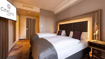 A CityClass hotel room with a large bed, a nightstand, and a wall-mounted TV.