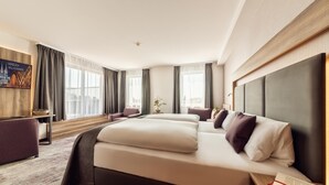 Una habitación de hotel moderna con una cama grande, un escritorio y vistas a la ciudad.