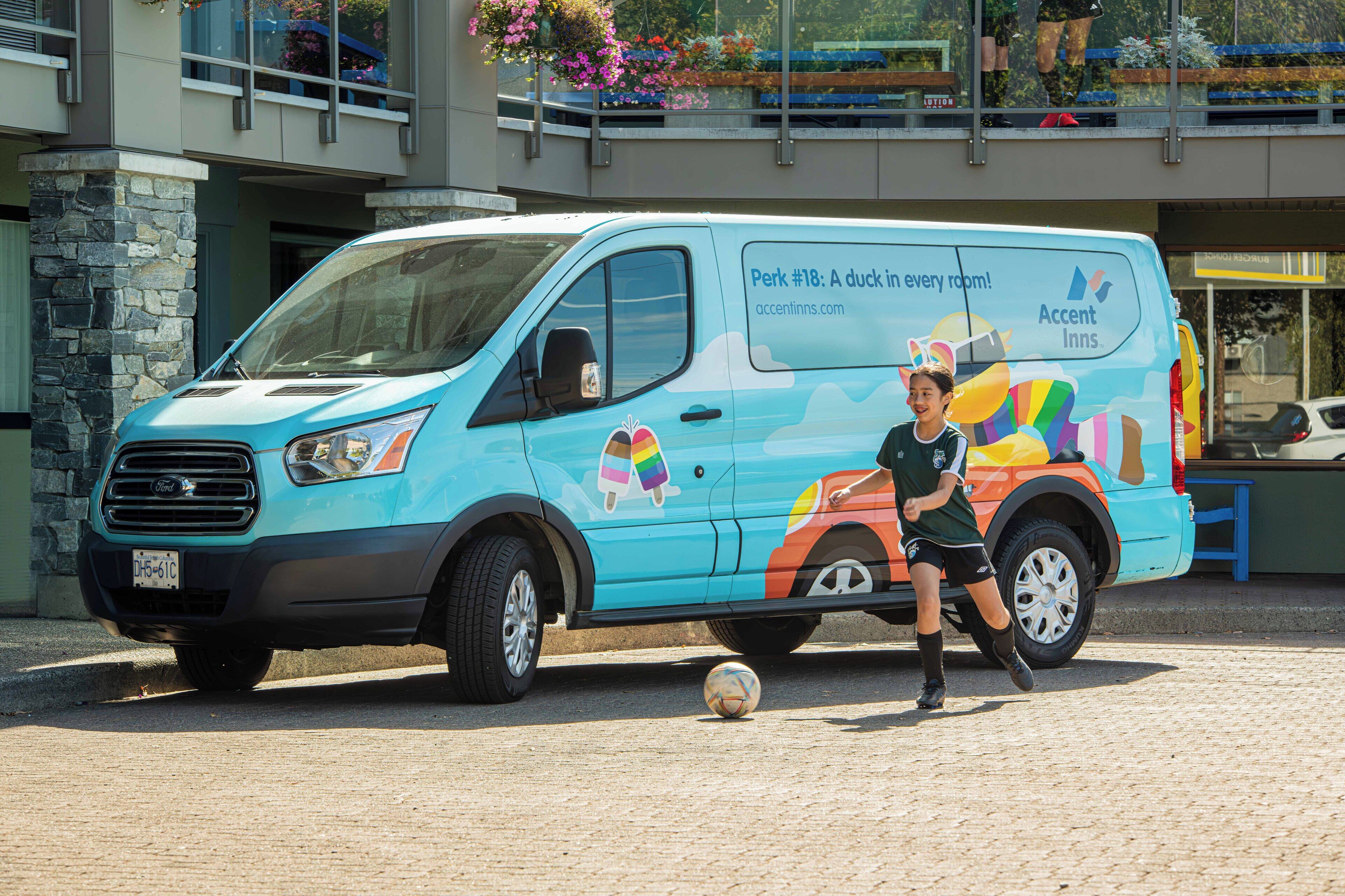 A blue van with a colorful design and text advertising a hotel.