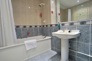 Un baño con bañera, lavamanos y ducha.