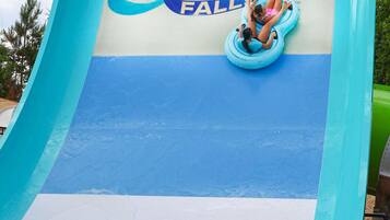 A water slide with the text "Fins Up Fall" and two people sliding down.