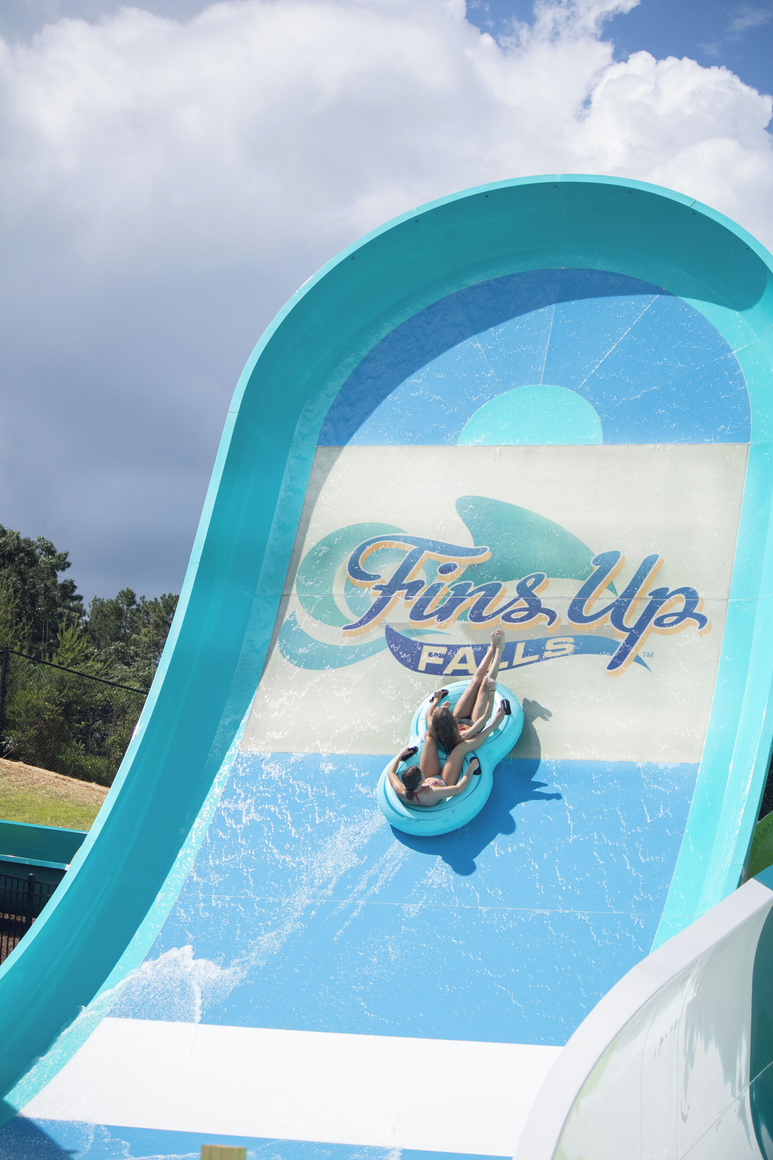A water slide with a person at the top, labeled "Fins Up Falls."