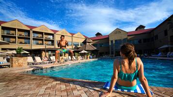 Relax by the pool surrounded by comfortable lounge chairs and umbrellas.