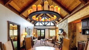 A spacious dining area with a wooden table, patterned chairs, and a chandelier. - Lanier Islands Resort (Buford)