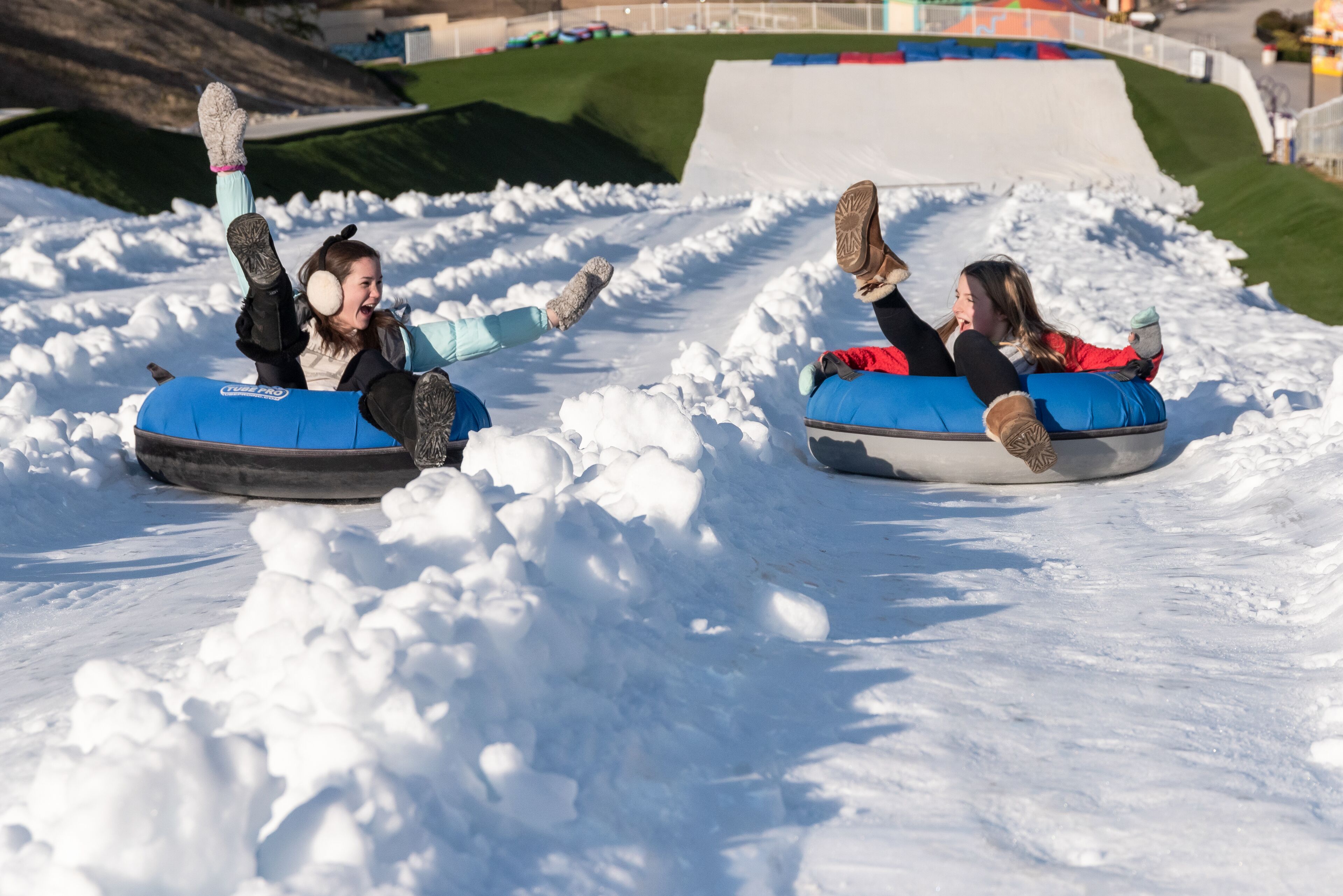 Two people on snow tubes at a snow park.
