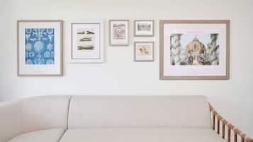 A wall with framed artworks and a sofa.