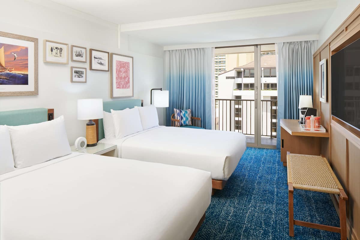 A hotel room with two beds, a desk, a chair, a TV, and a balcony with a view.