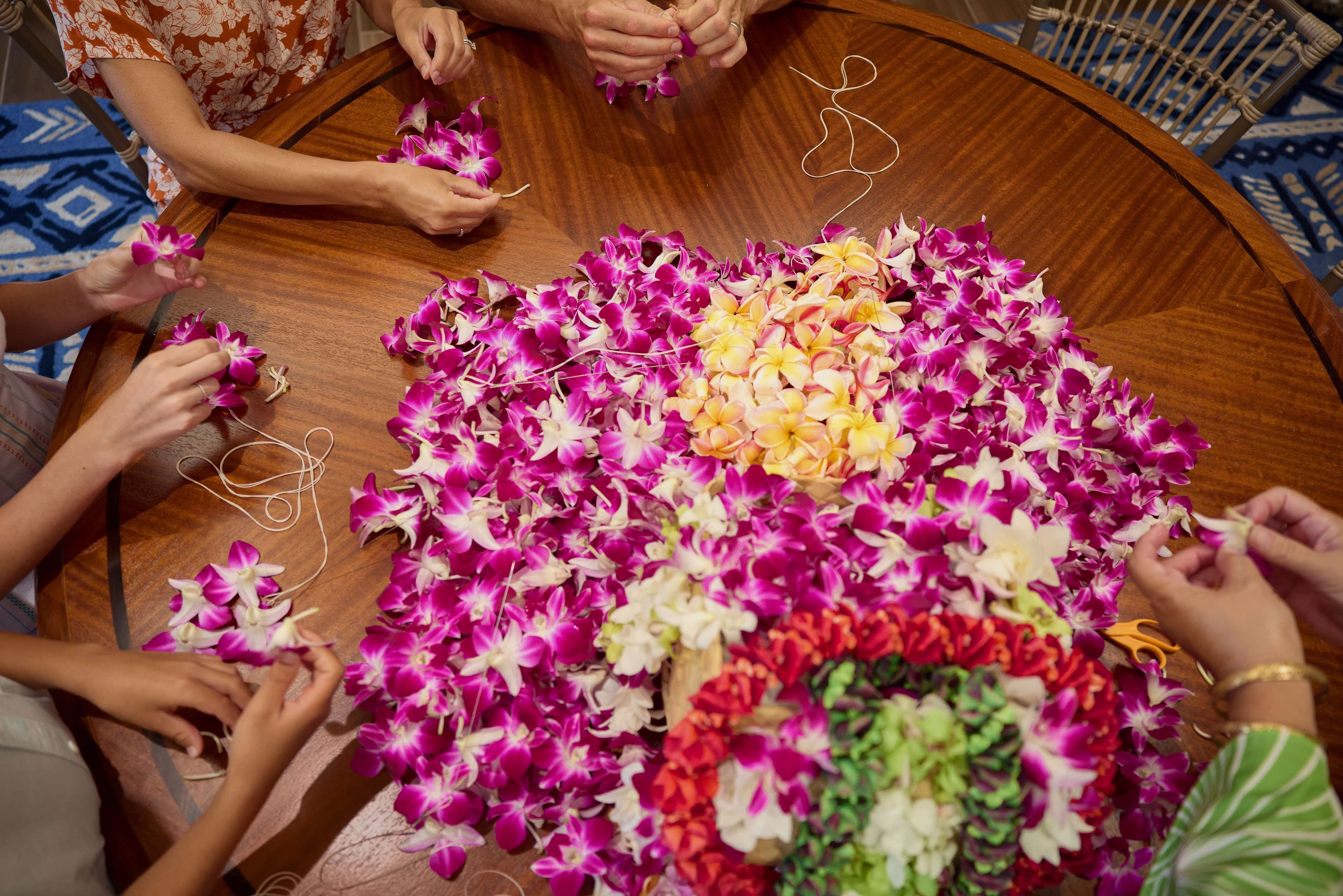 A round wooden table with a floral arrangement in the center.