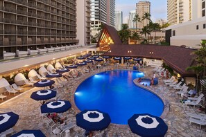 A hotel pool area with sun loungers and umbrellas, surrounded by high-rise buildings. - OUTRIGGER Reef Waikiki Beach Resort (Honolulu)