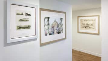 Three framed artworks on a wall in an indoor setting.