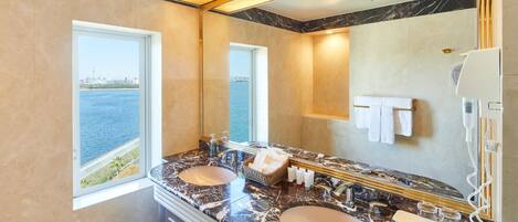 A bathroom with two sinks, a large mirror, and a view of the water.