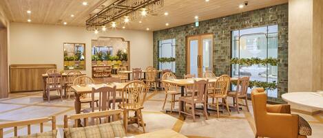 A spacious dining area with wooden furniture and a modern chandelier.