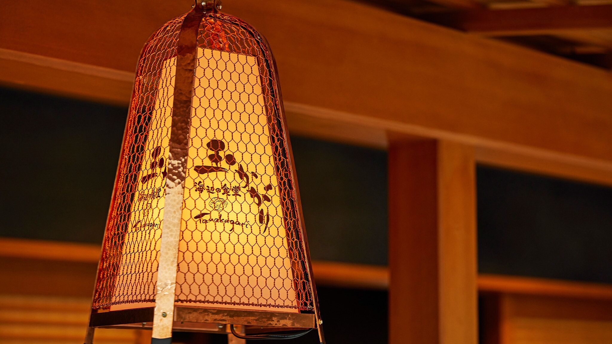Un farol colgante con diseño de malla y texto, probablemente usado para decoración o iluminación.