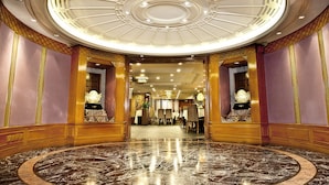 A grand lobby with a marble floor, a central circular ceiling design, and ornate wooden columns. - The Kimberley Hotel (Kowloon)