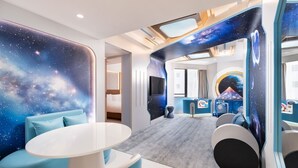 A modern room with a galaxy-themed wall, a round table, and a cozy seating area. - The Kimberley Hotel (Kowloon)