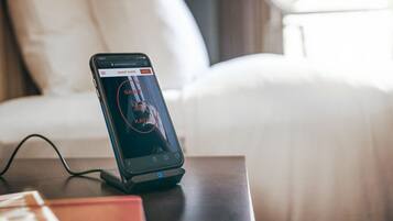 Un teléfono inteligente en un dock de carga en una habitación de hotel.