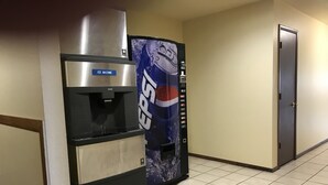 A vending machine with a Pepsi logo, a water dispenser, and a door in a hallway. - Days Inn by Wyndham Taos (Taos)