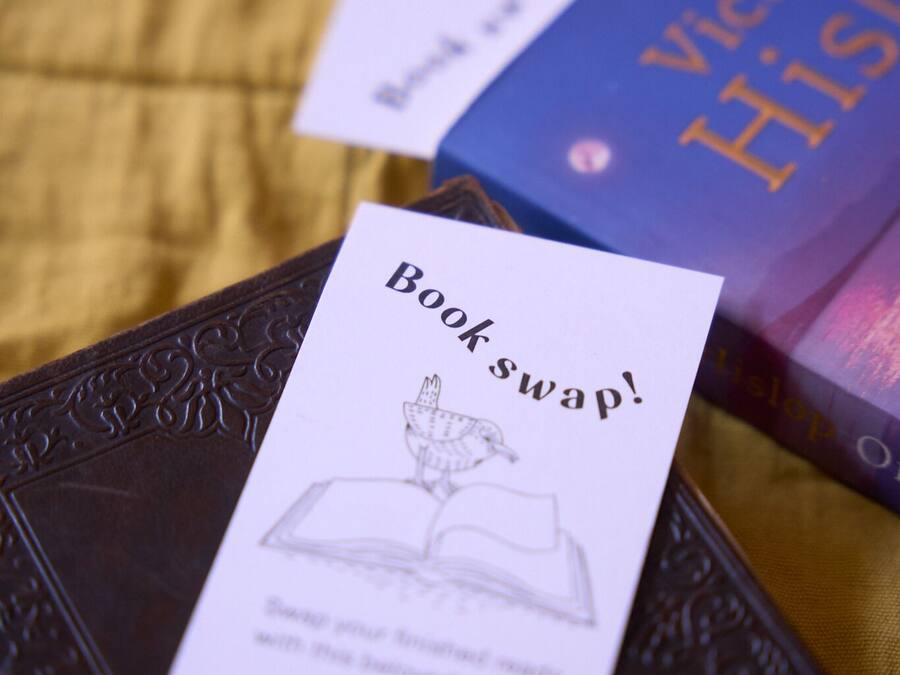 A book titled 'Victoria His' with a 'Book swap!' card on a textured surface.