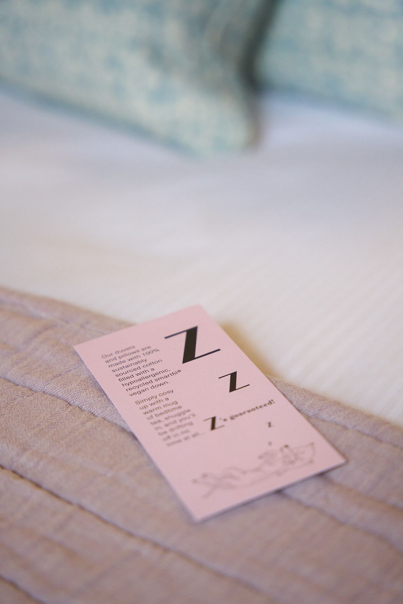 A pink card with text on a bed.