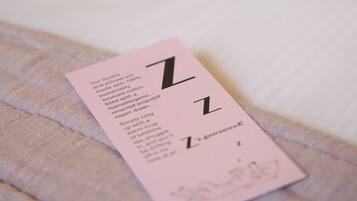 A pink card with text on a bed.
