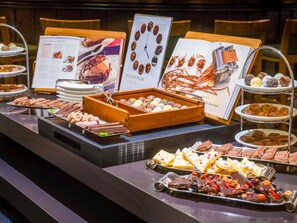 Ein Buffet mit verschiedenen Desserts und Pralinen, präsentiert auf Tabletts und Etageren.