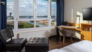 A hotel room with a bed, a desk, a chair, and a TV.