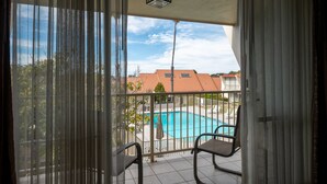Un balcon donnant sur une piscine, avec des chaises et une rambarde.