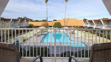 A pool area with a view of the surrounding buildings and palm trees.