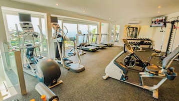 Un gimnasio con cintas de correr, elípticas y máquinas de pesas.
