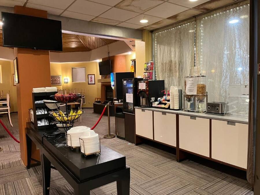 A hotel reception area with a counter, a television, and a buffet setup.