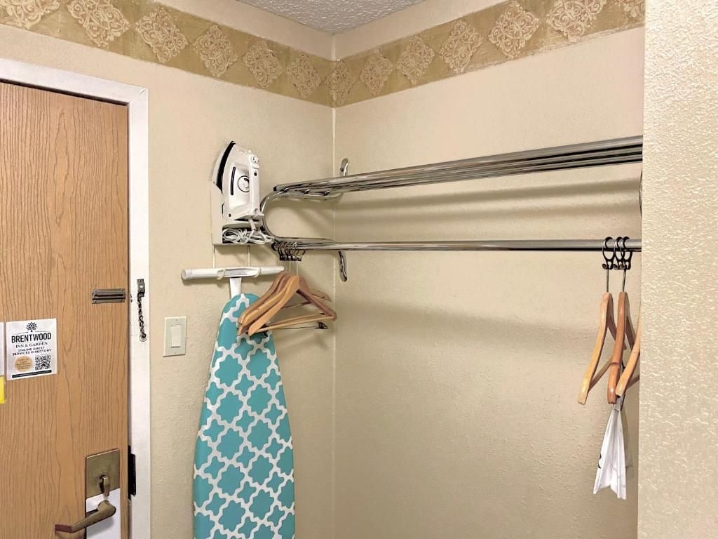 A bathroom with a towel rack, a hanging towel, and a door with a sign.