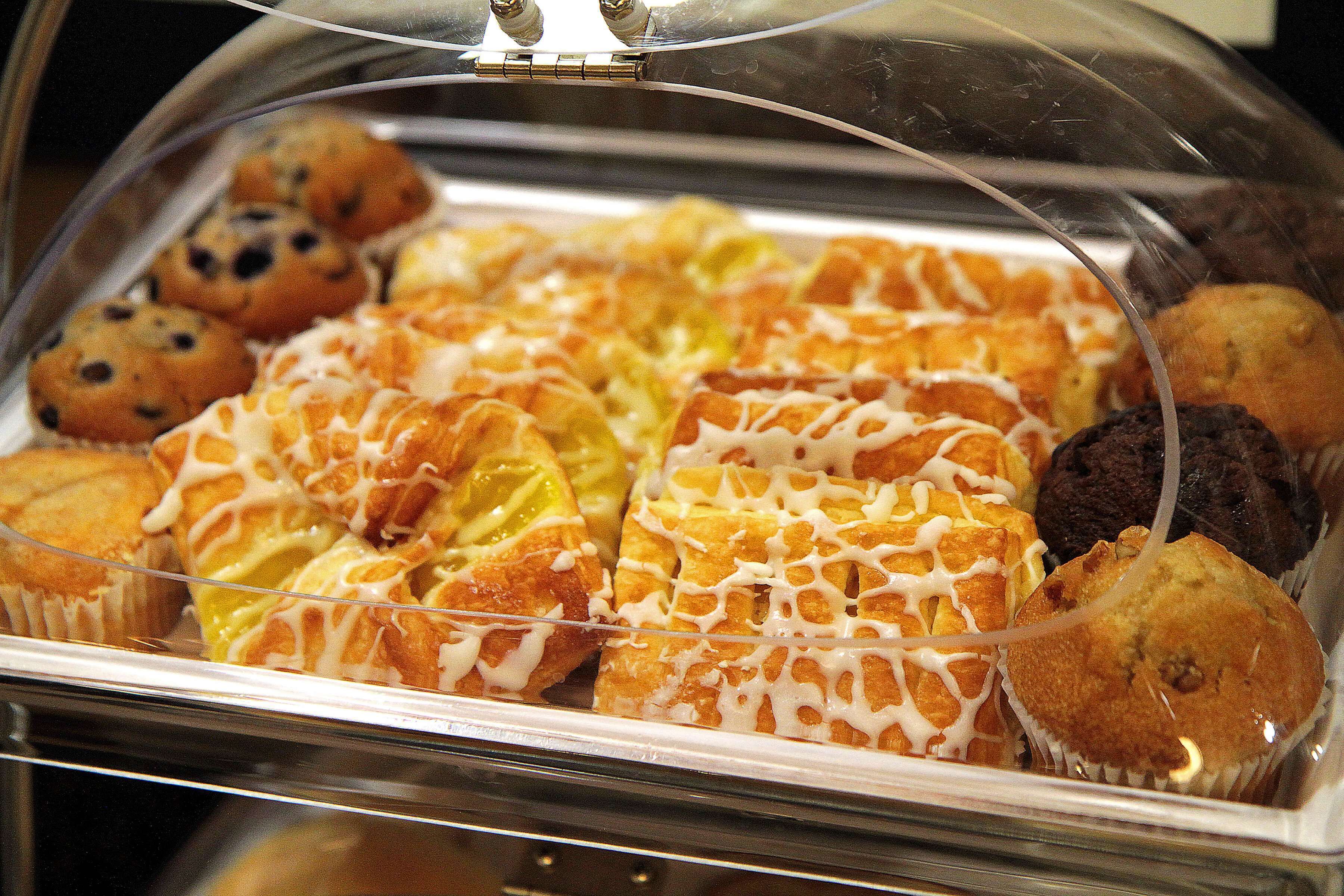 Una vitrina de vidrio con varios pasteles y magdalenas.