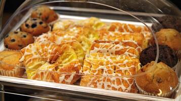Una vitrina de vidrio con varios pasteles y magdalenas.